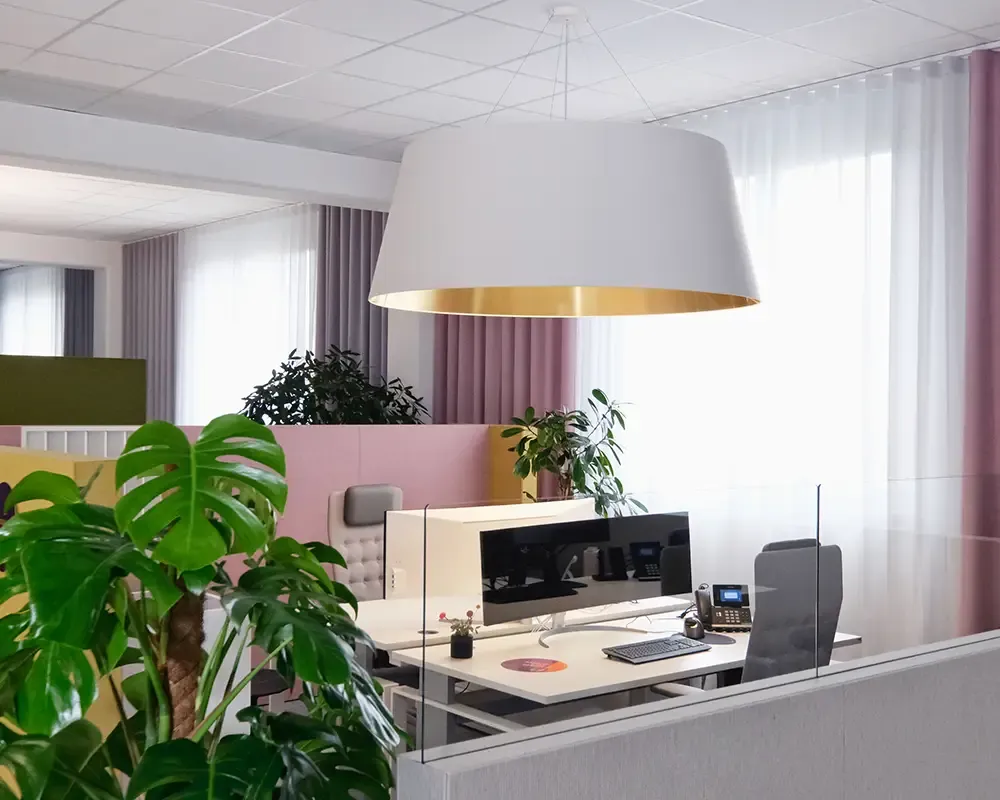 Arbeitsplatz unter einer großen Pendelleuchte mit goldenem Innenschirm