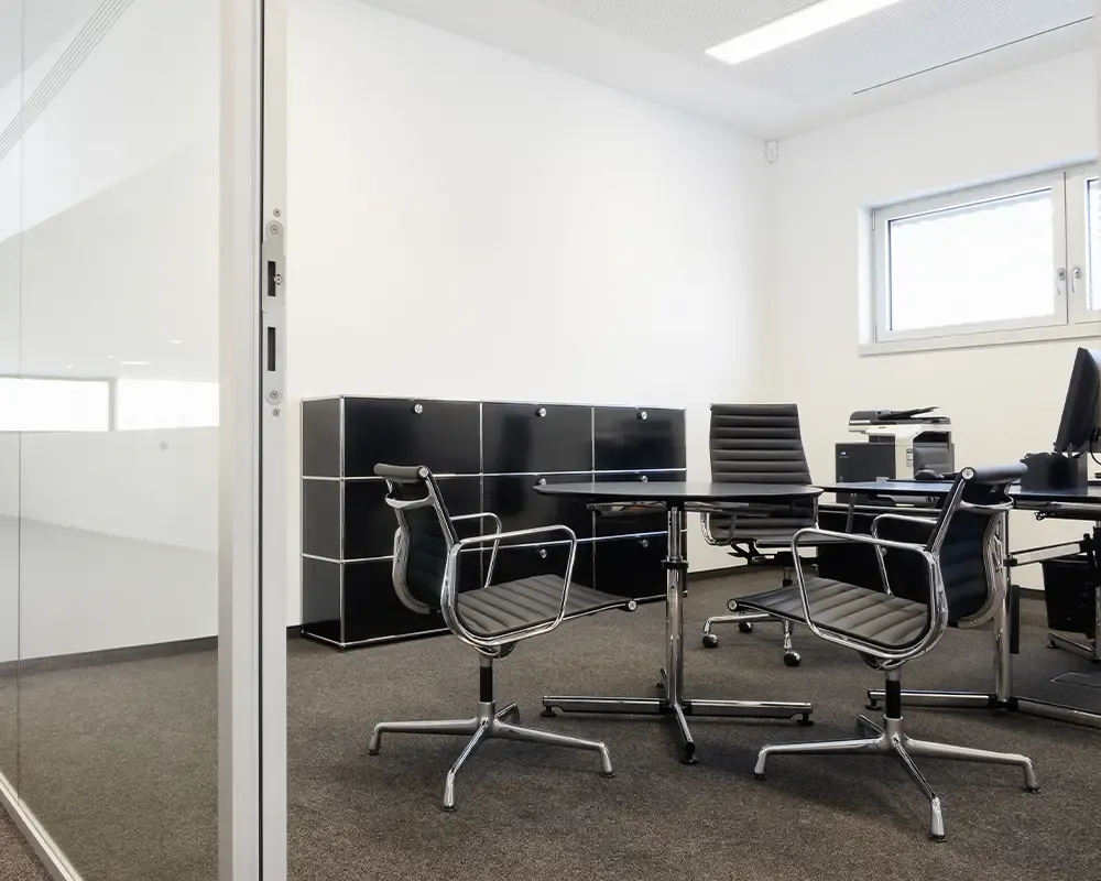 Büro mit schwarzem USM-Haller-Sideboard und verchromten Konferenzstühlen