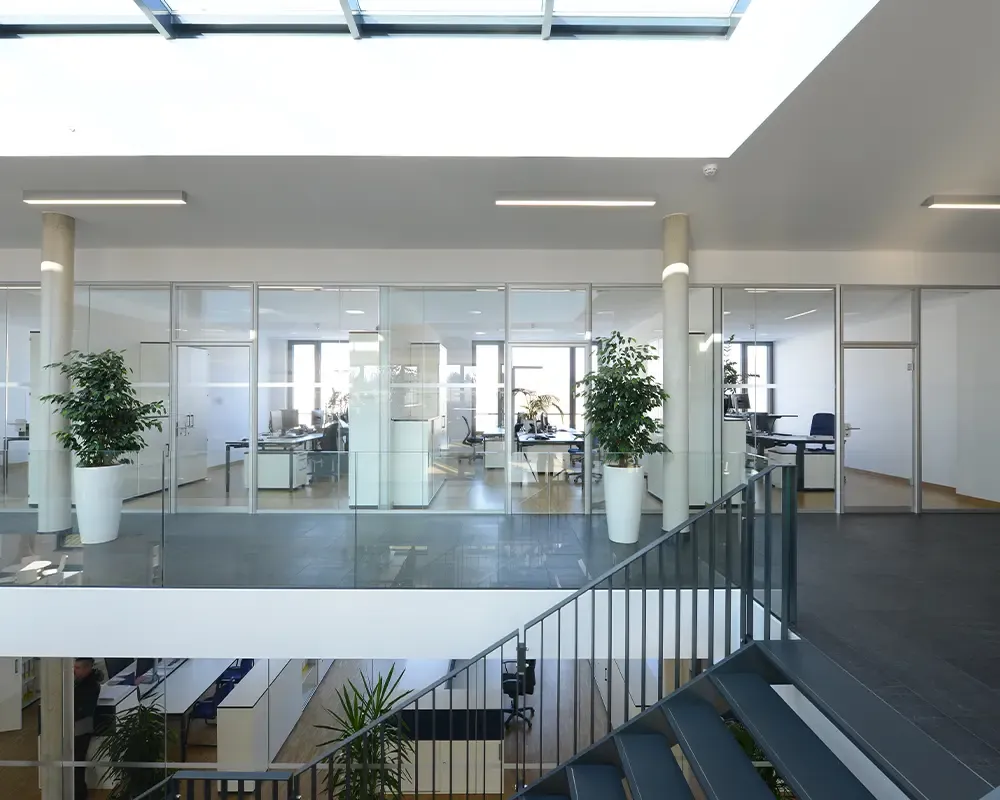 Blick über die Galerie auf verglaste Büros unter einem Oberlicht
