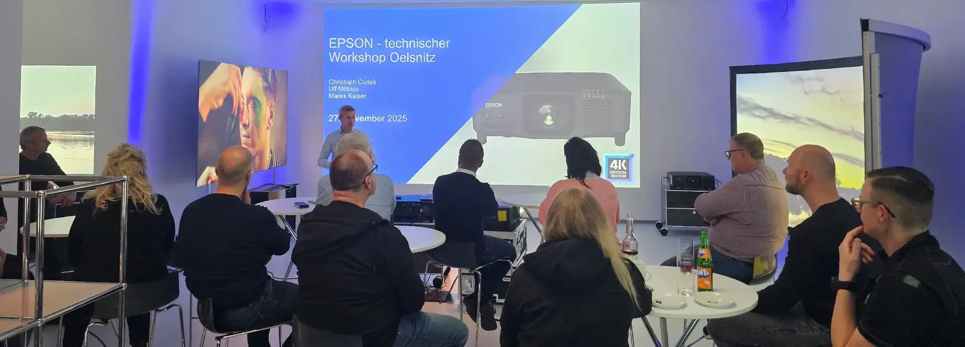 Publikum an Stehtischen vor der Projektionswand des Epson-Workshops
