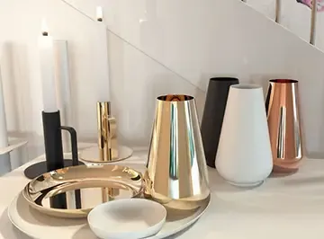 Wohnaccessoires in Gold, Schwarz und Weiß auf einer Ablage: Vasen, Schalen und Kerzenhalter