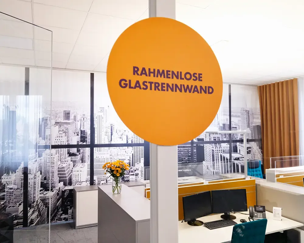Orangefarbenes Hinweisschild „Rahmenlose Glastrennwand“ im Büro