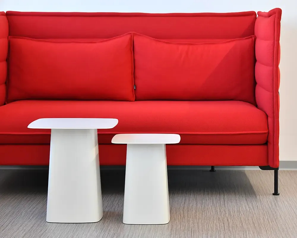 Rotes Hochlehnersofa mit zwei weißen Beistelltischen