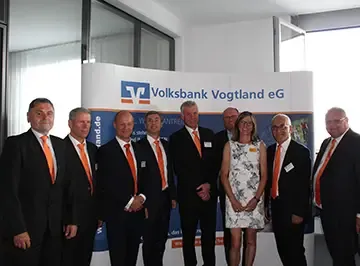 Gruppenbild vor der Stellwand der Volksbank Vogtland eG