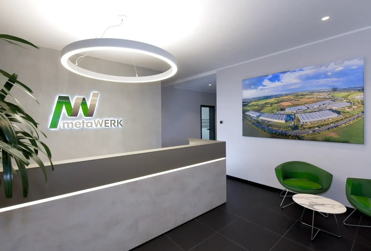 Tresen im Eingangsbereich mit großem MetaWerk-Logo an der Wand