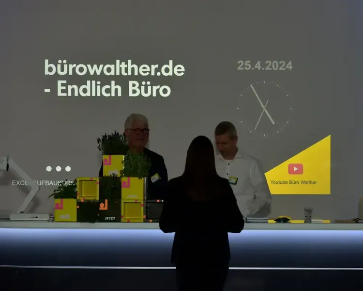 Projektion „bürowalther.de – Endlich Büro, 25.4.2024“ über einer Theke