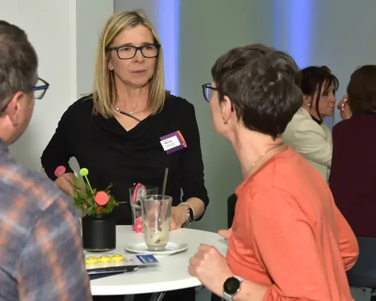 Zwei Besucherinnen im Gespräch an einem Stehtisch