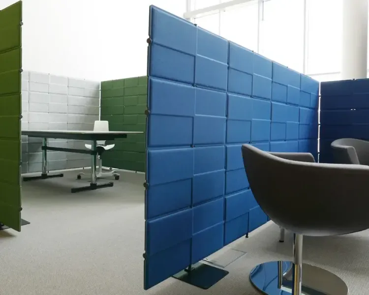 Freistehende Akustikstellwände in Blau, Grün und Weiß gliedern das Foyer