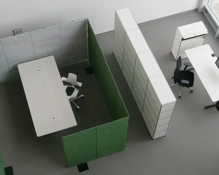 Blick von oben auf einen mit grünen und weißen Akustikwänden abgeteilten Arbeitsbereich