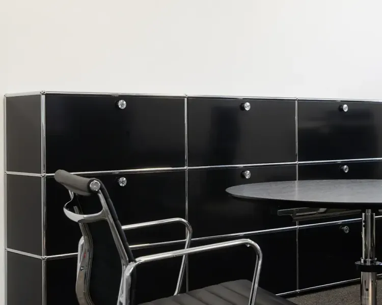 Schwarzes USM-Haller-Sideboard mit rundem Tisch und Lederstuhl