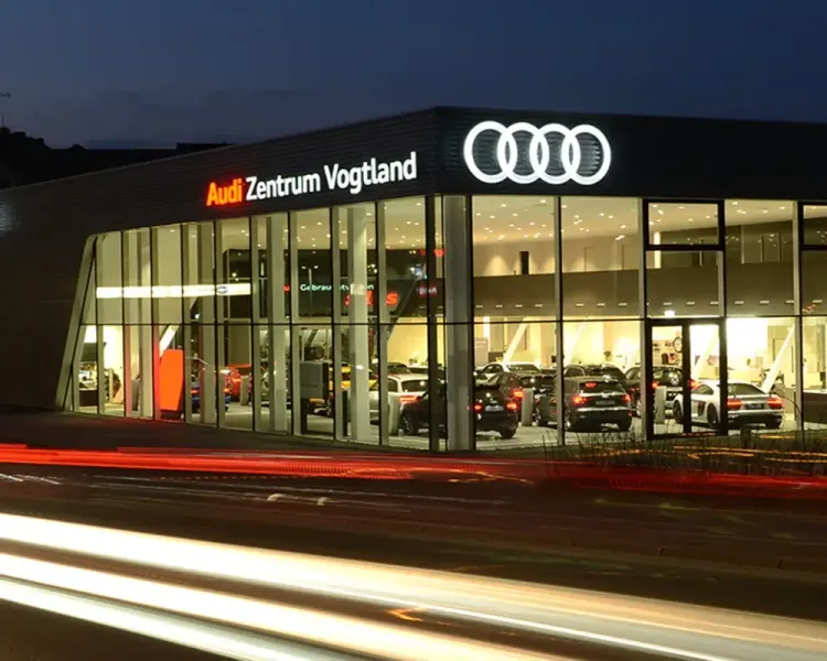 Audi Zentrum Vogtland bei Nacht mit beleuchteter Glasfassade