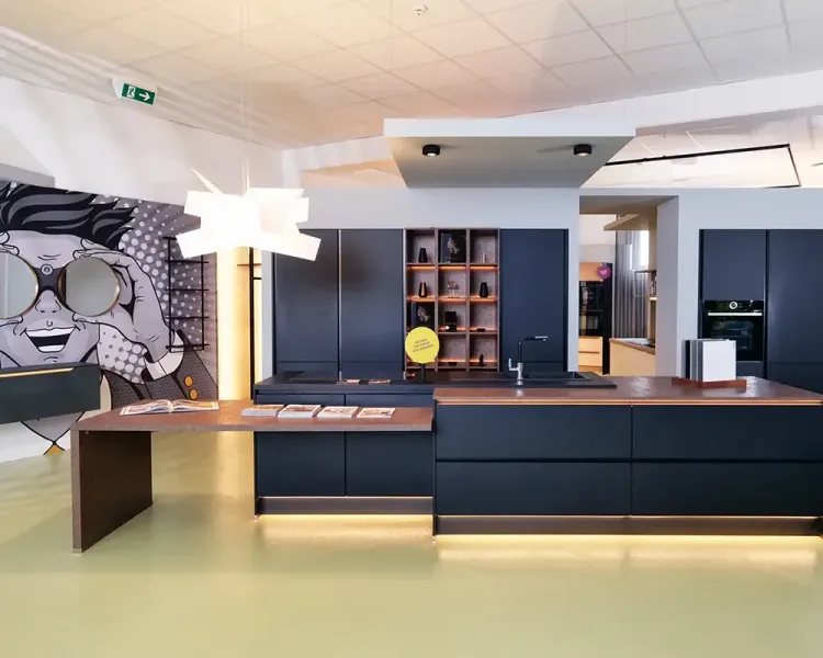 Küchenausstellung im Showroom mit dunkelblauer Kochinsel und Wandbild