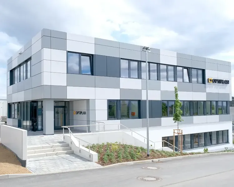 Firmengebäude der Optiplan Oelsnitz mit grau-weißer Fassade
