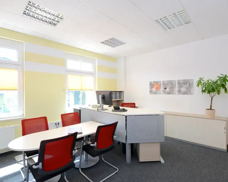Büro mit gelb gestreifter Wand, Besprechungsrunde und Bildreihe