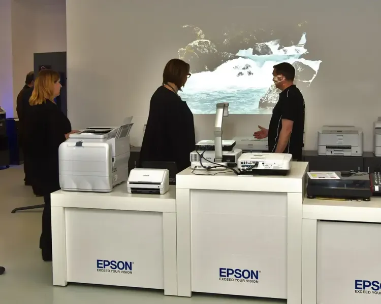 Besucher an der Epson-Technikausstellung vor einer Wandprojektion