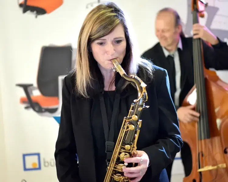 Saxofonistin und Kontrabassist spielen in der Stuhlausstellung