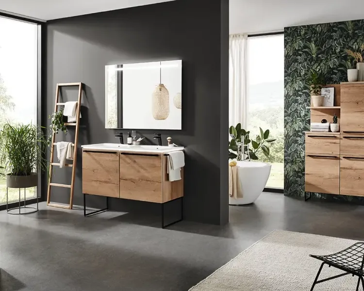 Badezimmer mit Holzwaschtisch, Doppelbecken und freistehender Wanne vor Blätterwand