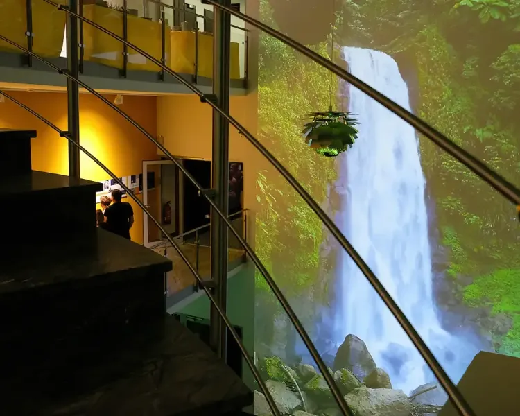 Wasserfall-Projektion neben der Wendeltreppe im Foyer