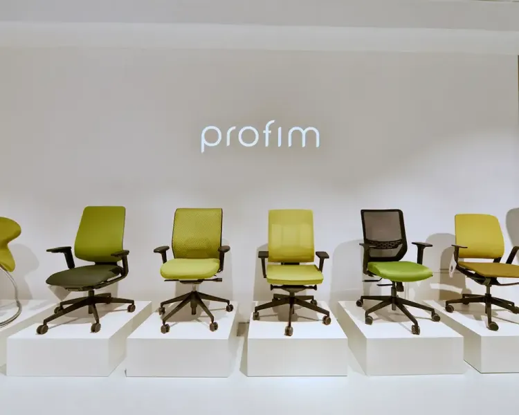 Bürodrehstühle in Grüntönen auf weißen Podesten unter dem Schriftzug „profim“