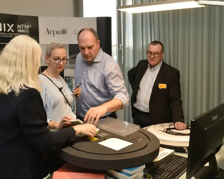 Vier Personen an einem Beratungstisch mit Materialmustern
