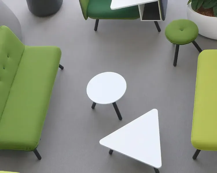Blick von oben auf eine Sitzgruppe in Grüntönen mit weißen Beistelltischen