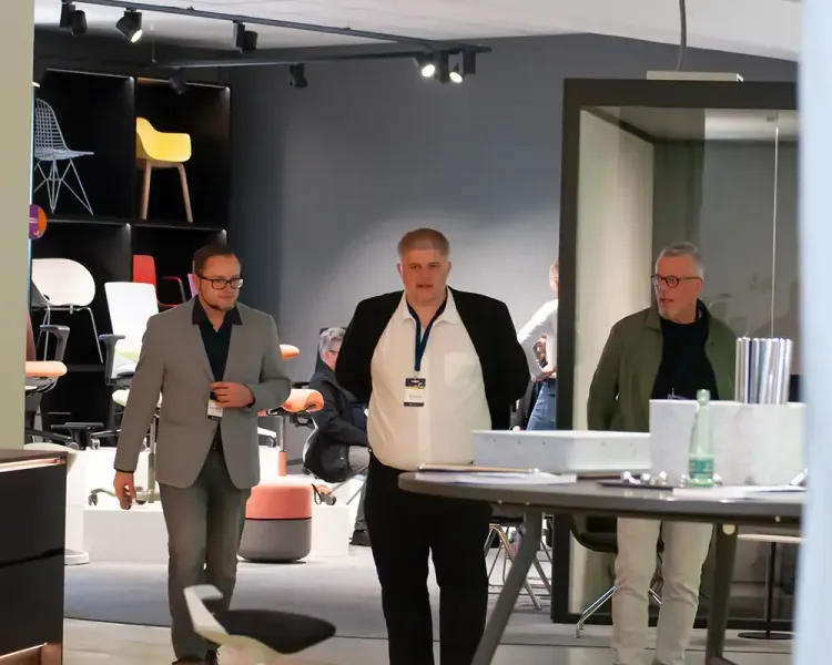 Drei Besucher gehen durch die Stuhlausstellung