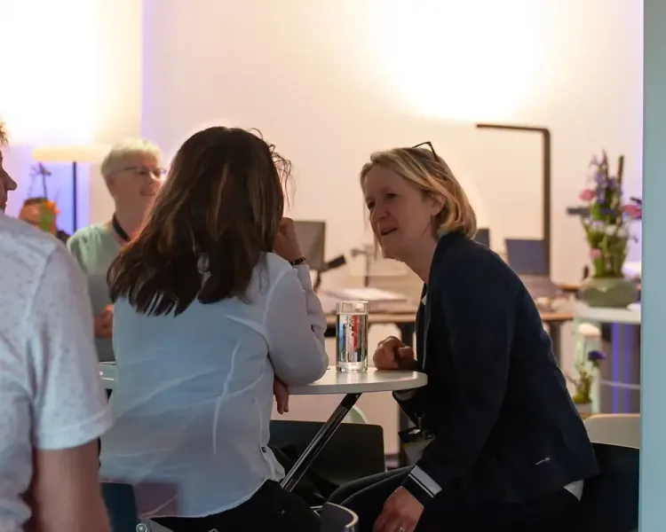 Zwei Besucherinnen im Gespräch an einem Stehtisch